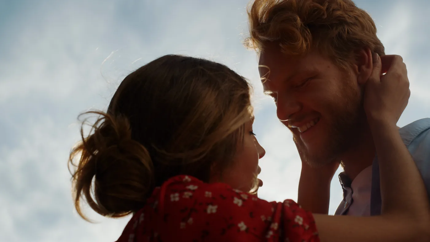 Two people embrace in warm sunlight.