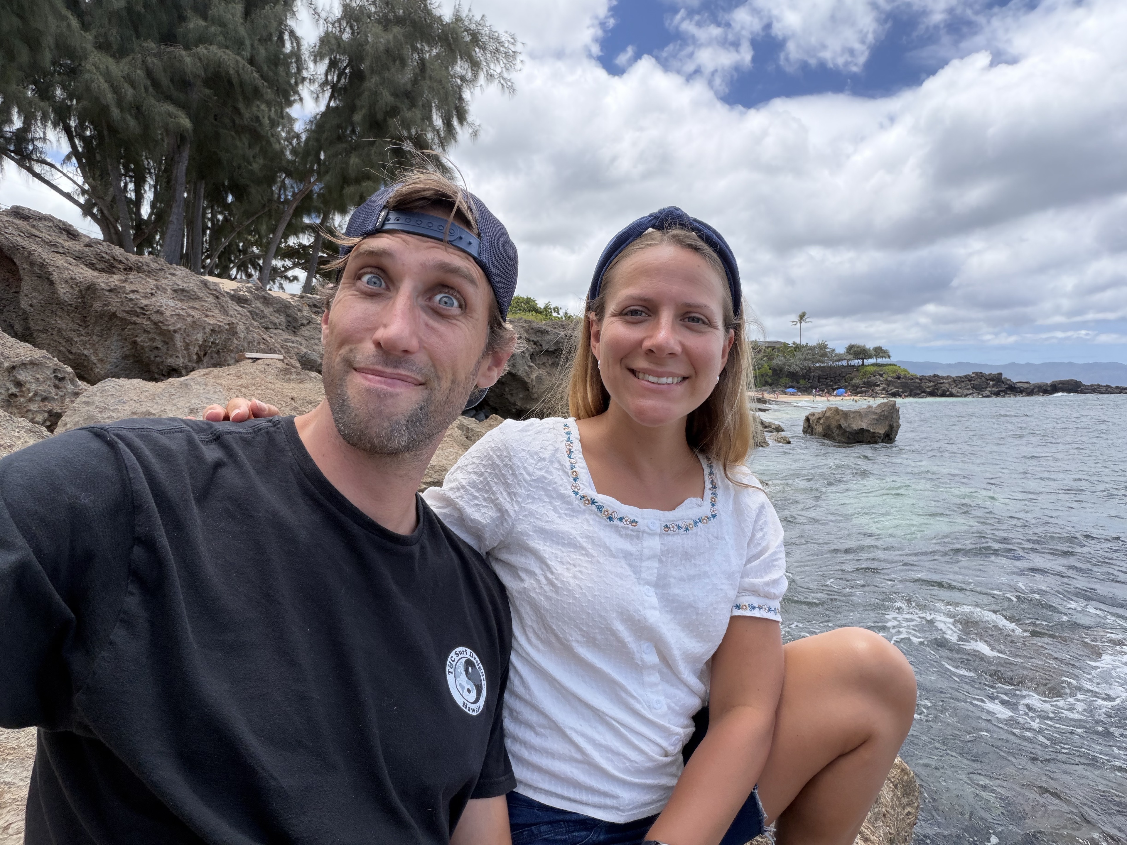 James making a playful face beside Julie at the beach