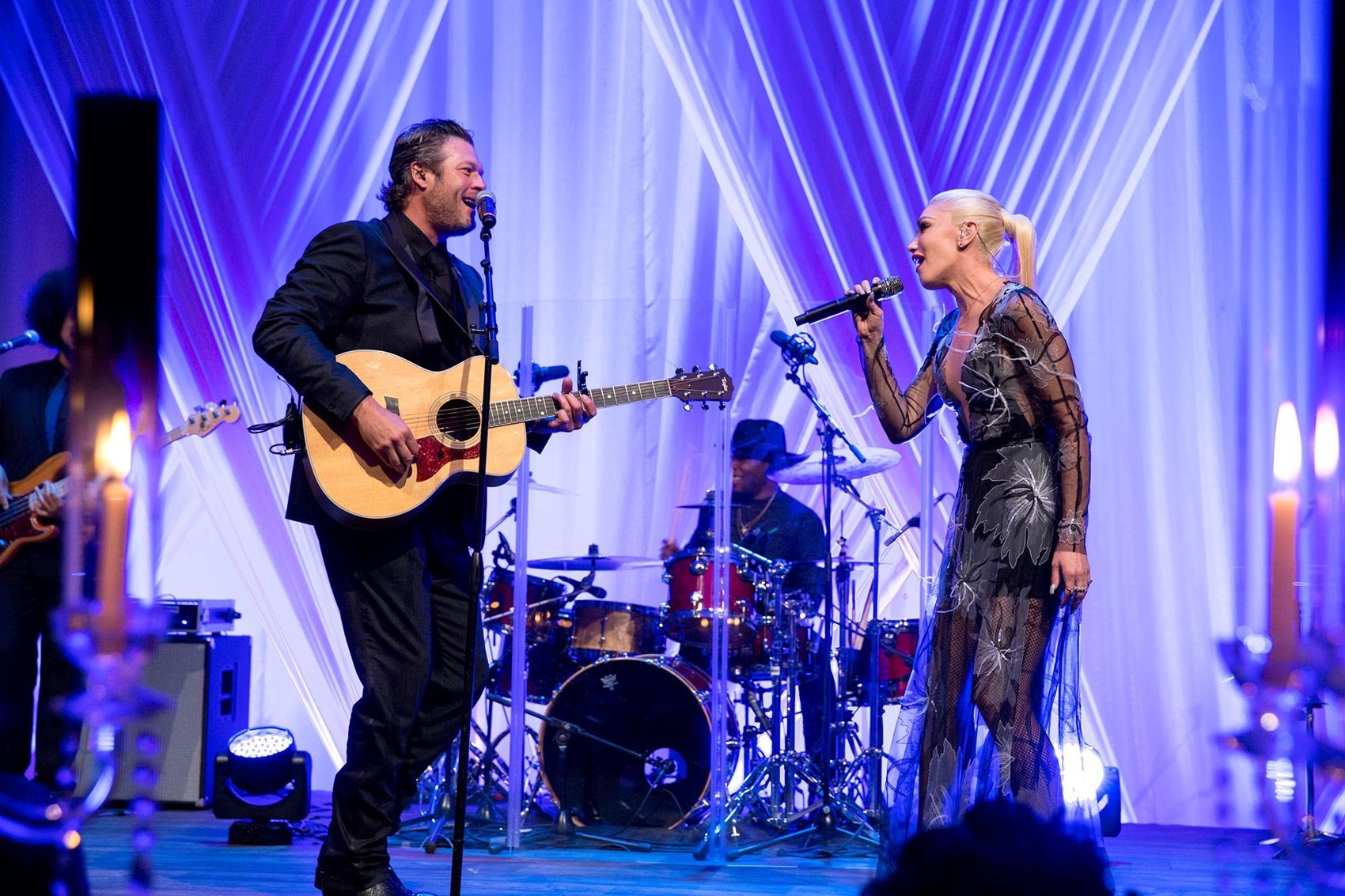 Blake Shelton and Gwen Stefani performing together on a stage with blue curtains at the 2016 state dinner.