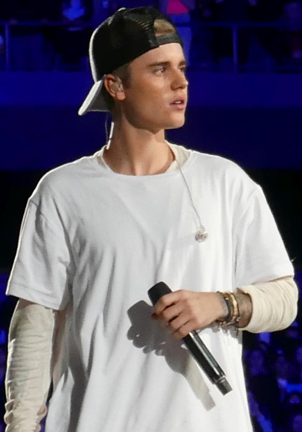 Justin Bieber holding a microphone at an event in Rosemont in 2015.